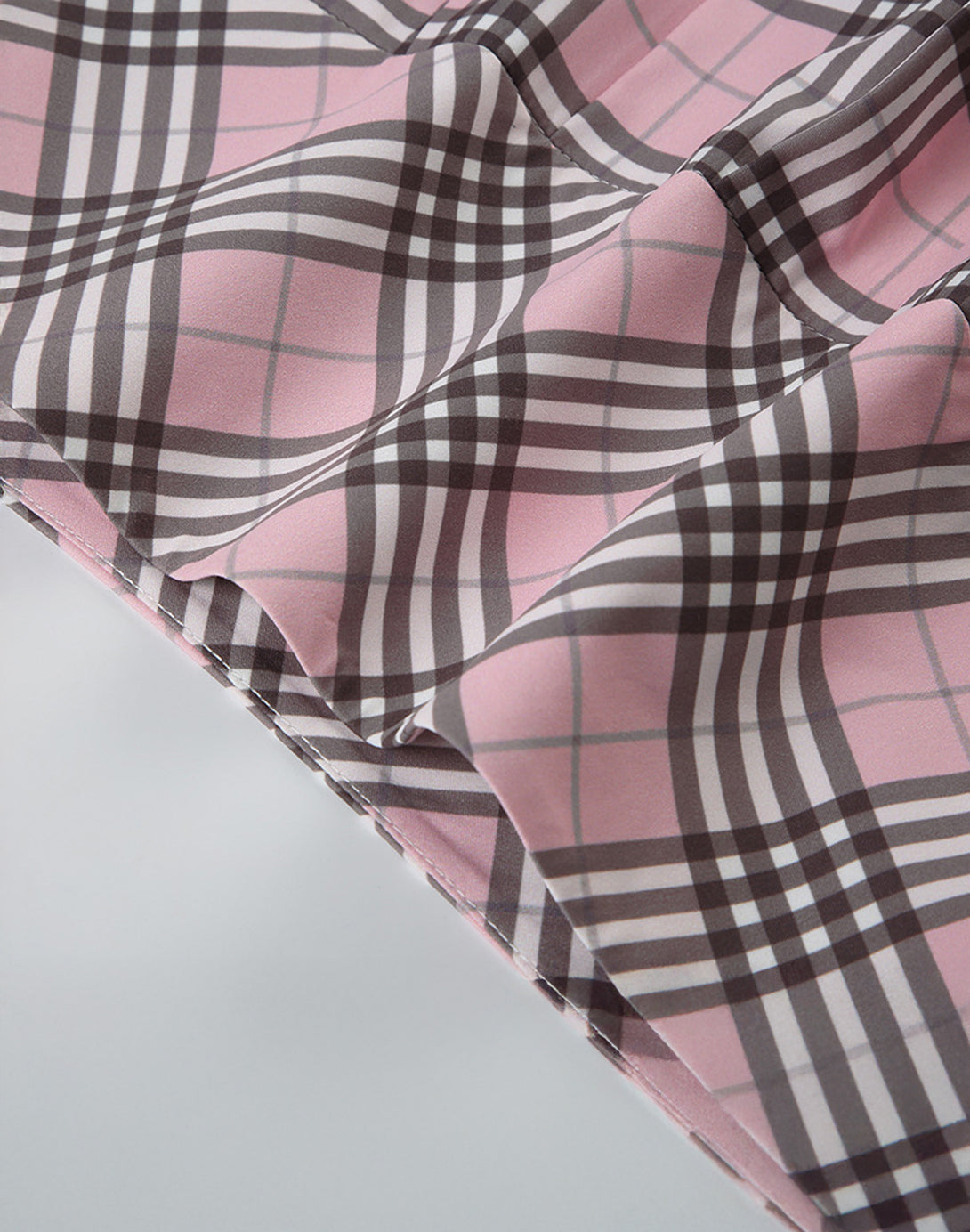 The crisp pleated hem of the mini skirt, an element of its hyper feminine and dollette style design.