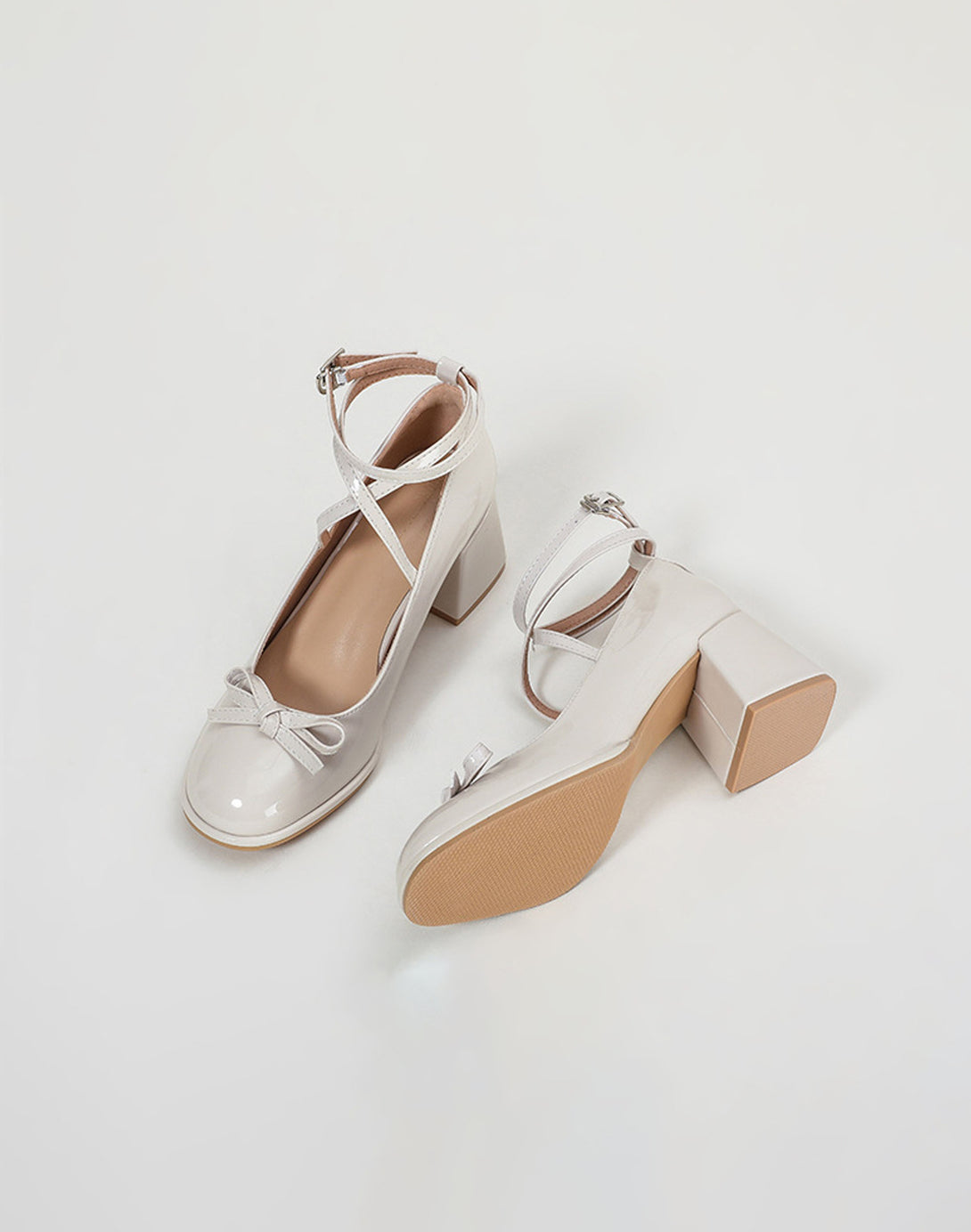 flat lay of ivory patent ballet heels with block heel and ribbon-like ankle straps