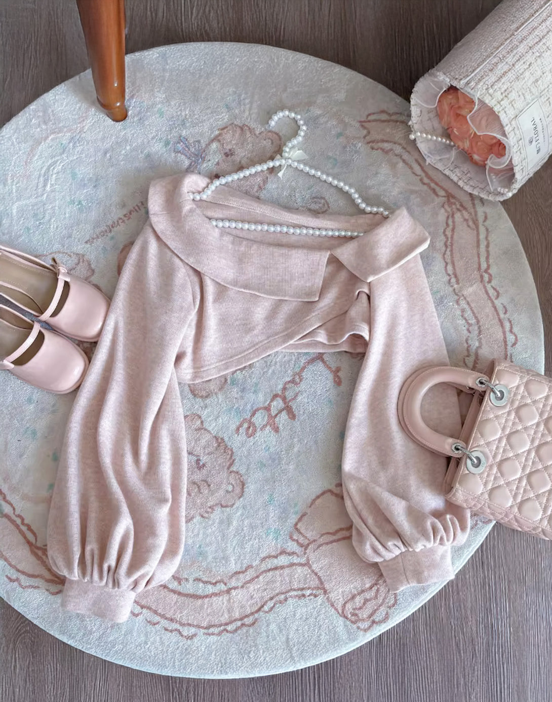 Flat lay of pretty princess dress and pink shrug, featuring a feminine floral print and delicate ruffle details for a soft, romantic look.