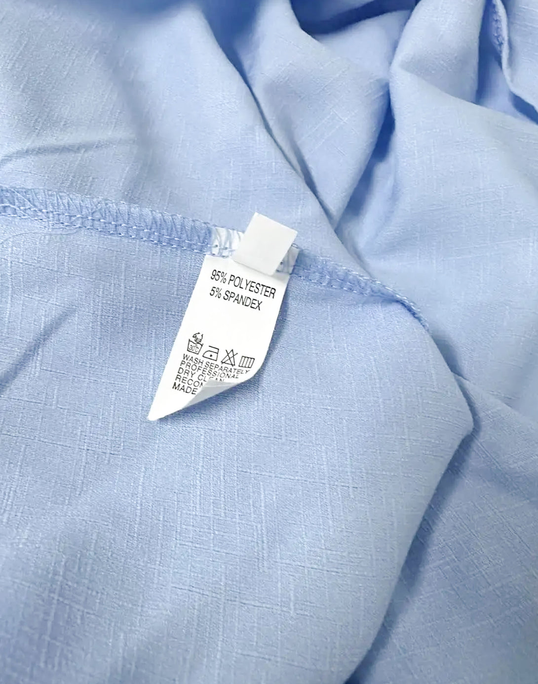 Close-up of fabric and label inside blue romper showing texture and material tag