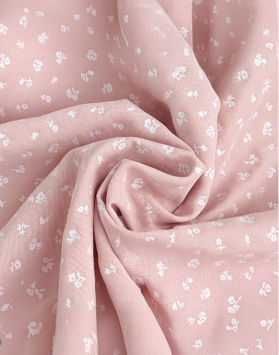 close-up of pink crepe fabric with small white flower print