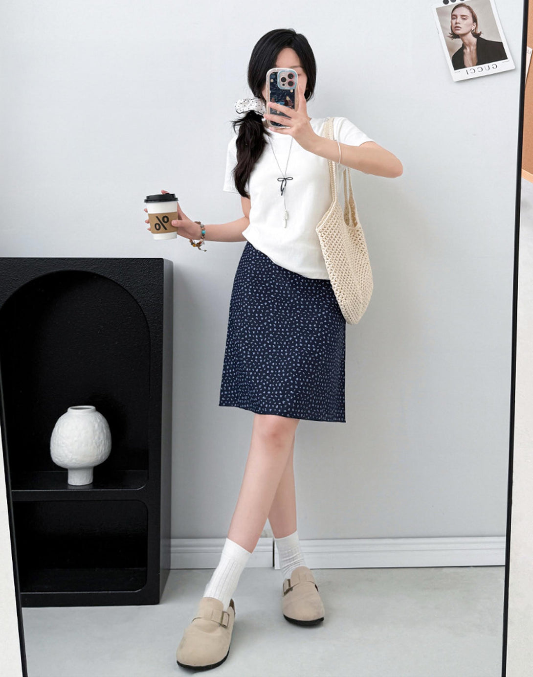 woman in blush navy floral mini skirt styled with white tee