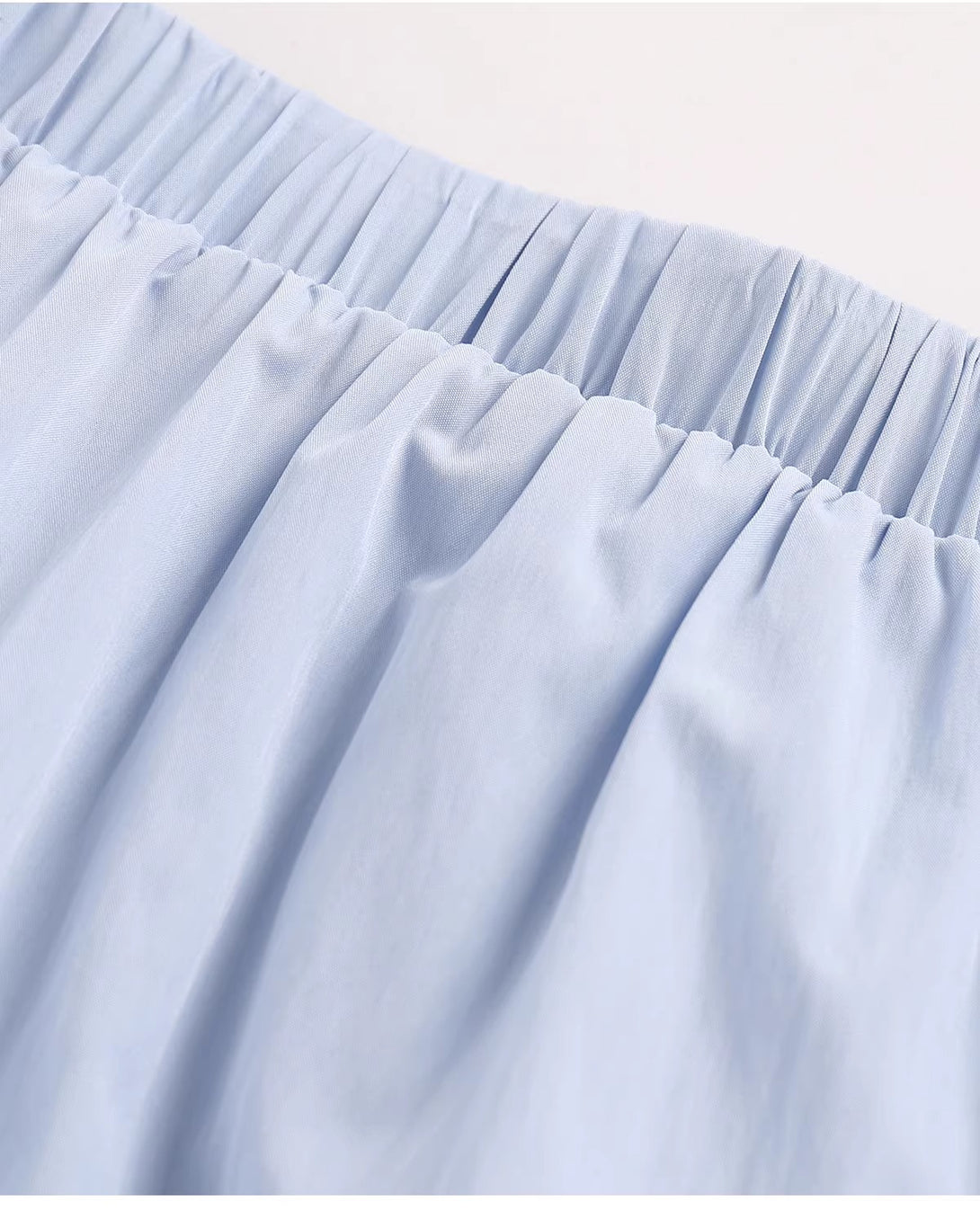 A detailed view of the smocked elastic waistband on the blue maxi skirt.