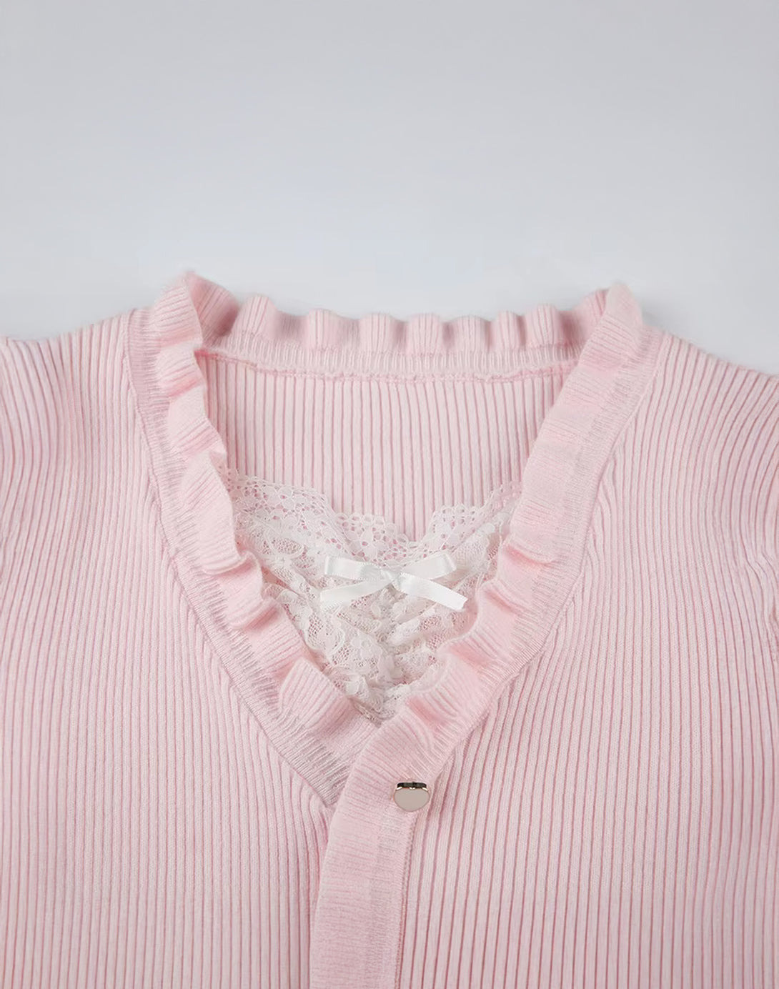 Close-up of the neckline and ruffle details on the Lace Bow Ruffle Knit Cardigan, adding a hyper feminine touch to the overall design.