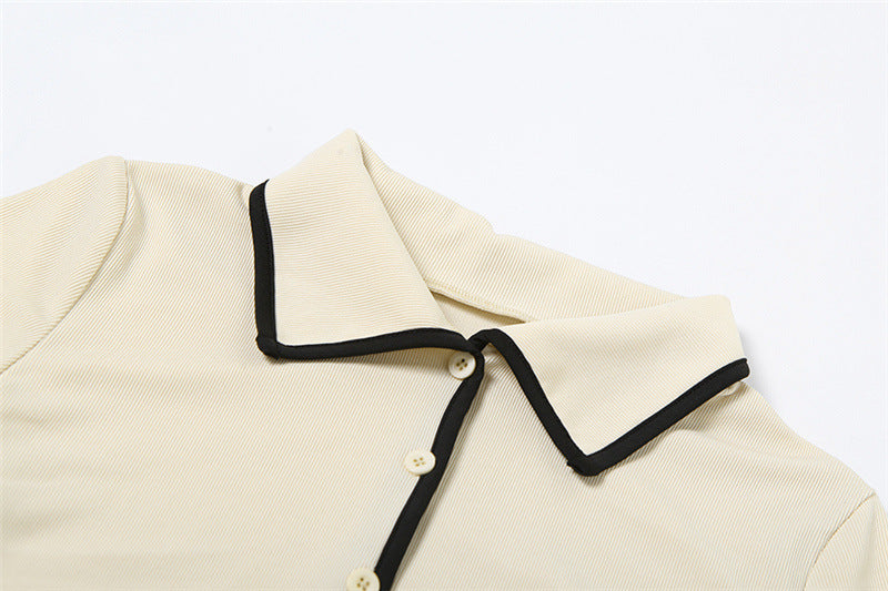 Collar and button detail of cropped cream collared shirt from elegant two-piece outfit