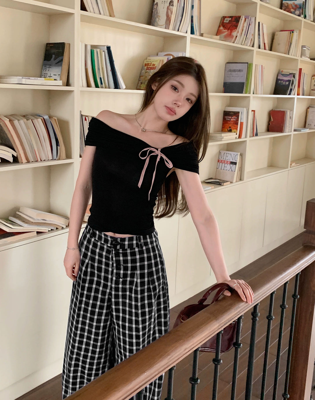 Model wearing black off-shoulder lace bow top, showcasing dollette style and cute Korean fashion. Flattering fit and feminine vibe.