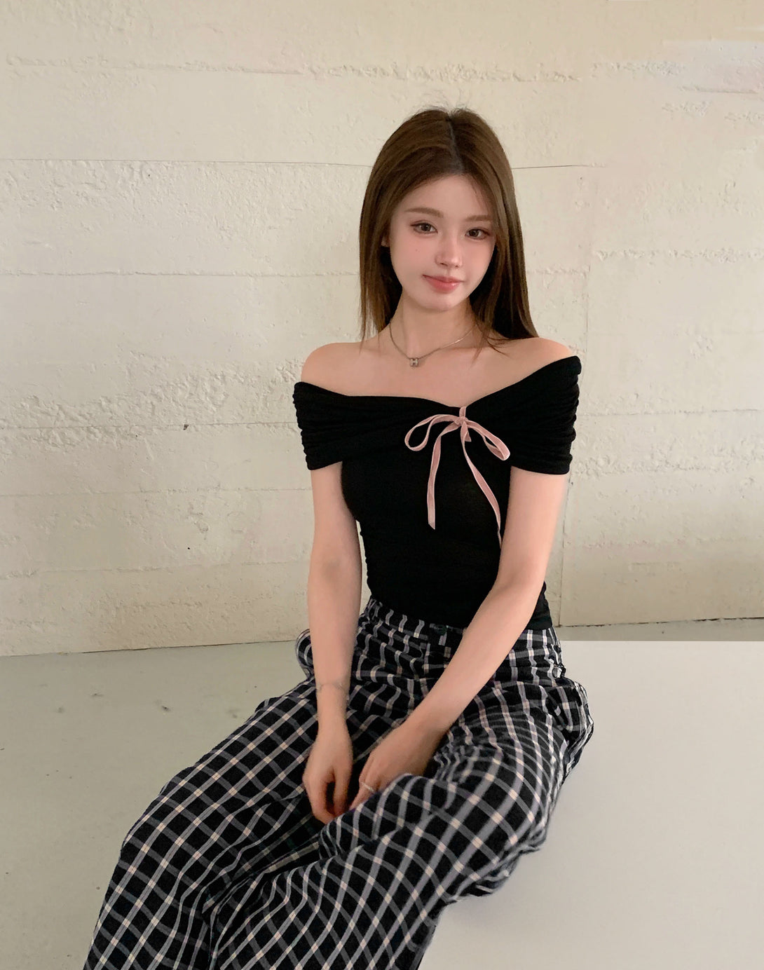 Front view of model in off-shoulder lace bow top, capturing coquette and dark coquette aesthetics. Perfect for feminine fashion and trendy looks