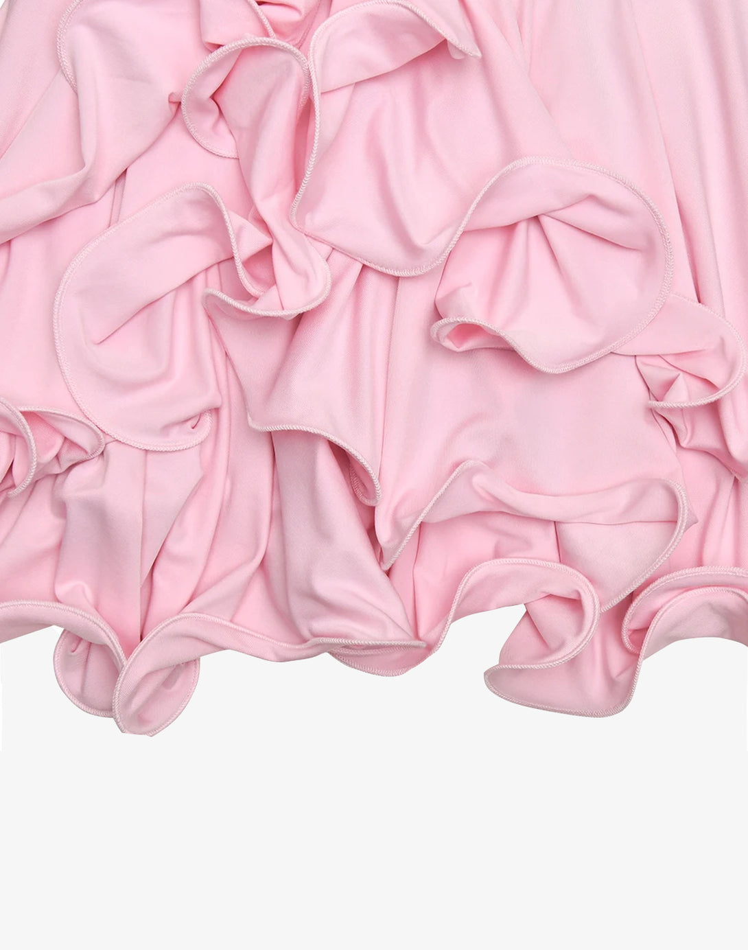 Detailed close-up of soft ruffles on the hem of a pink mini bodycon ruffle dress, adding a playful touch to a feminine look.