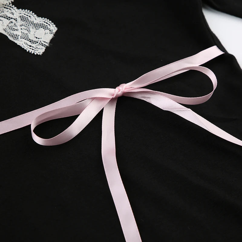 Closeup of the delicate pink satin ribbon tied in a bow around the waist.