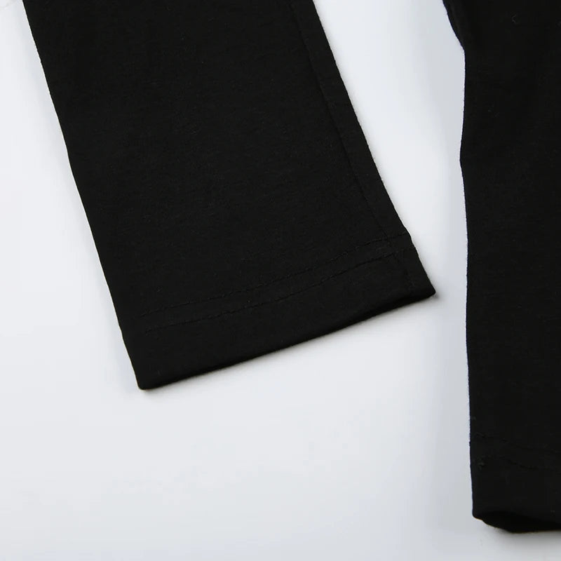 Closeup of the soft black fabric and the clean hem of the long sleeve.