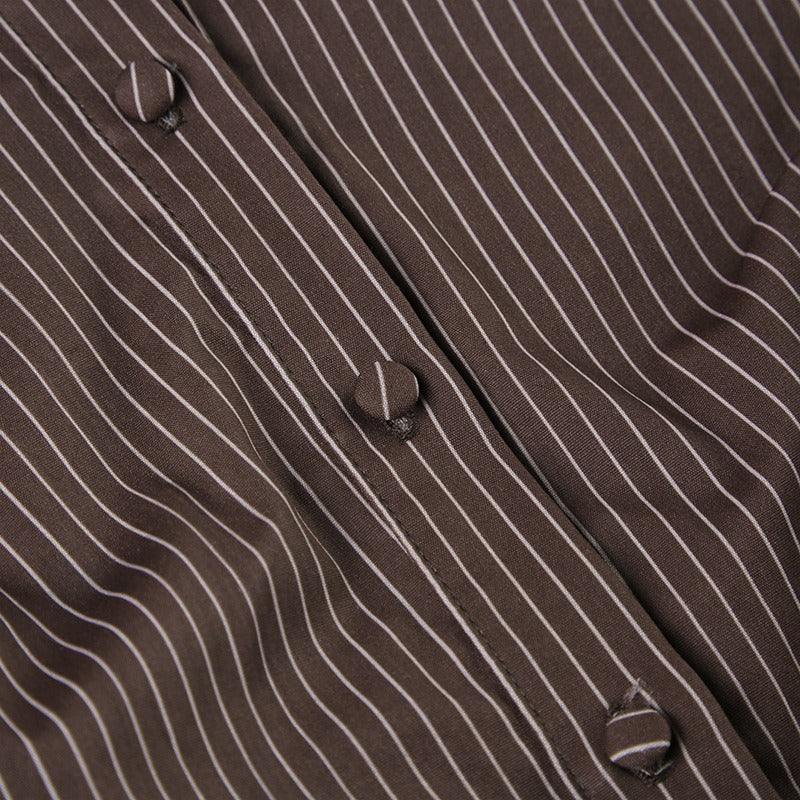 Closeup of the brown stretch pinstripe fabric and button details on the formal fashion blouse.