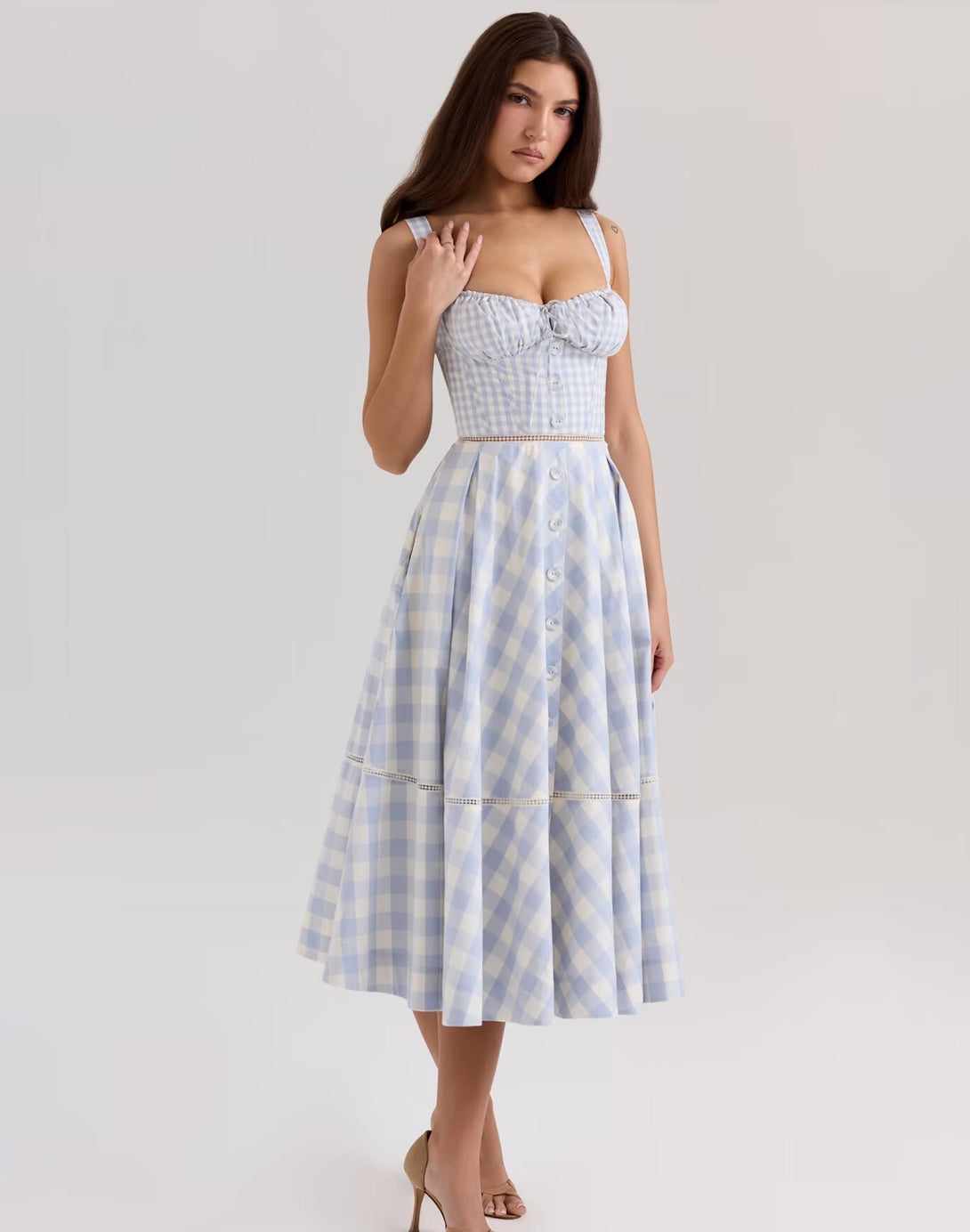 model wearing blue gingham dollette dress with sweetheart neckline and button-down skirt