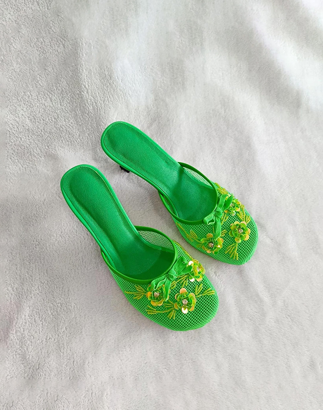 vibrant green tropical mesh mules with yellow floral appliqué and low heel shown top view
