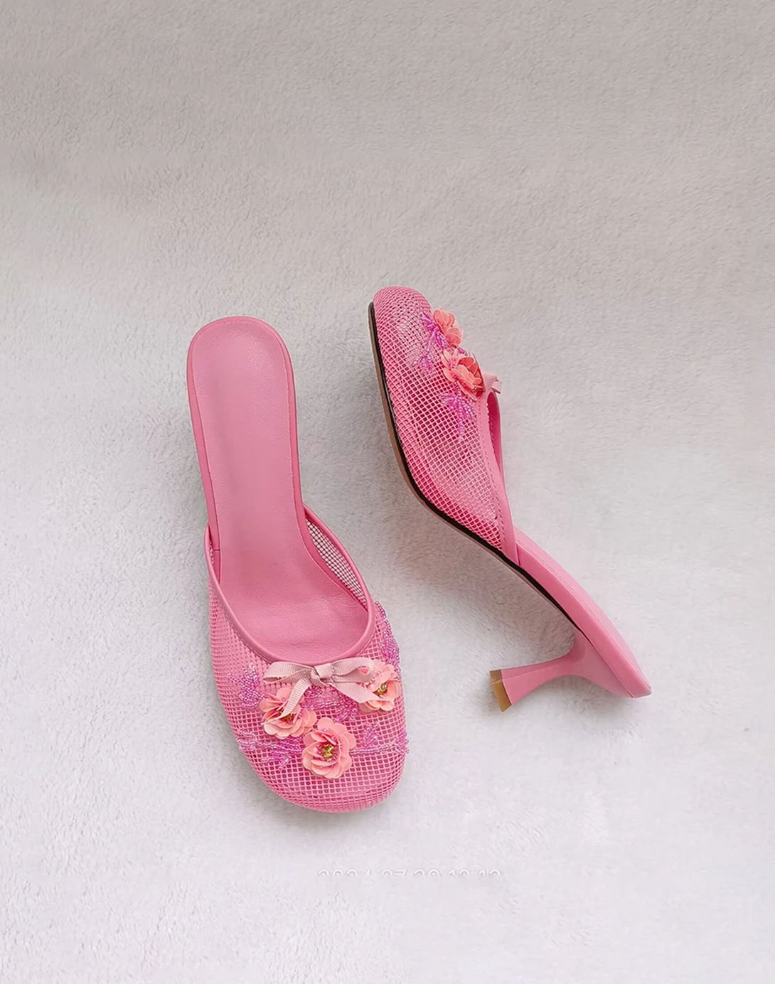 side view of candy pink mesh kitten heel mules with sequin flower and bow details