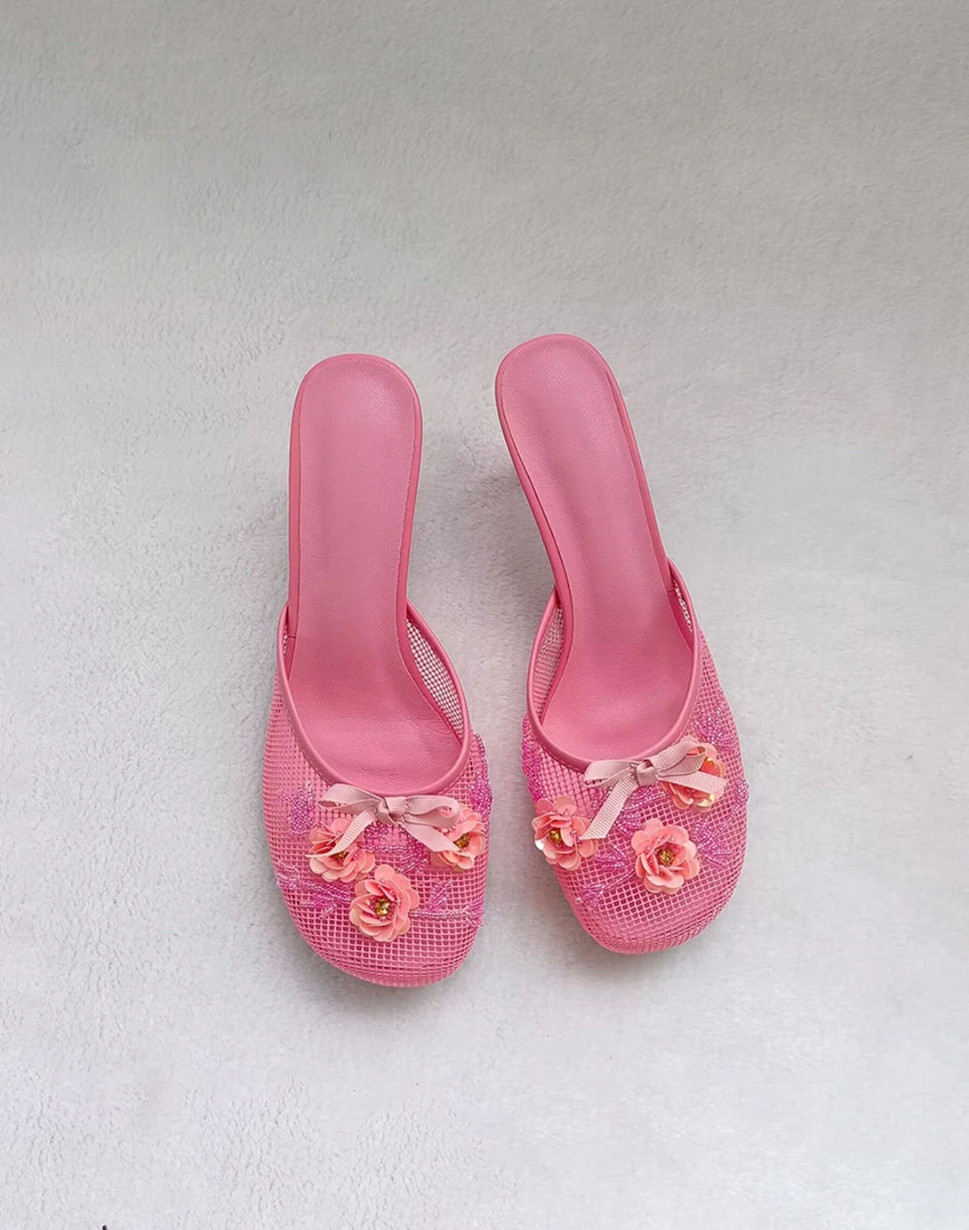 pink mesh mules with floral appliqué and kitten heel shown top view on white background