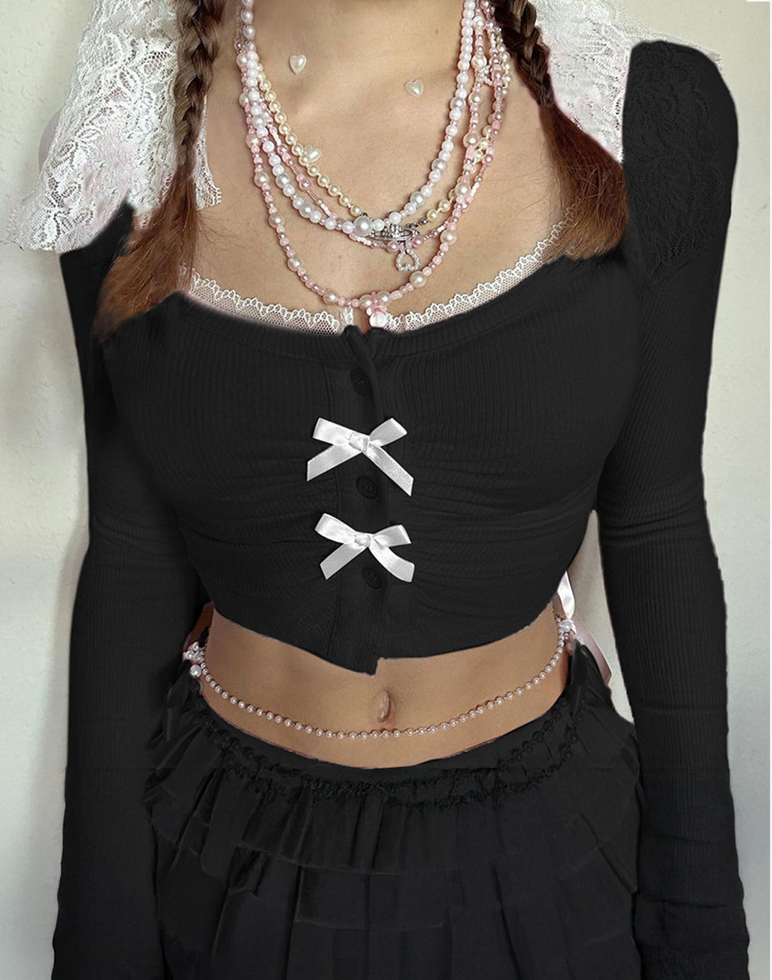 Close-up of a black ruched bow crop top with button detailing, perfect for cute South Korean fashion and hyper feminine style.