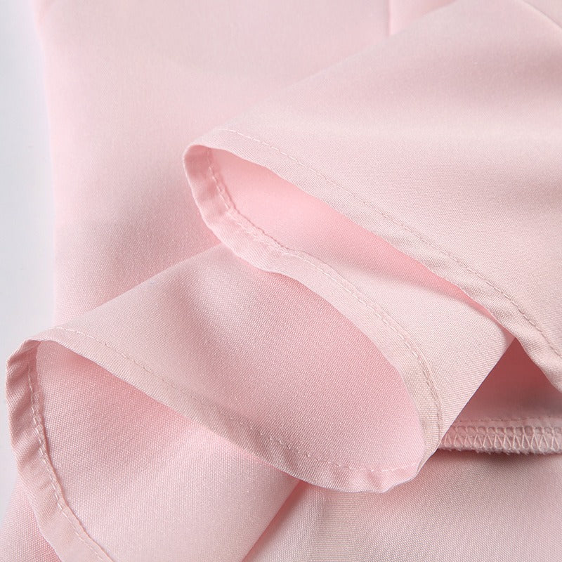A detailed shot highlighting the soft, flared ruffle hem of the pink blouse.