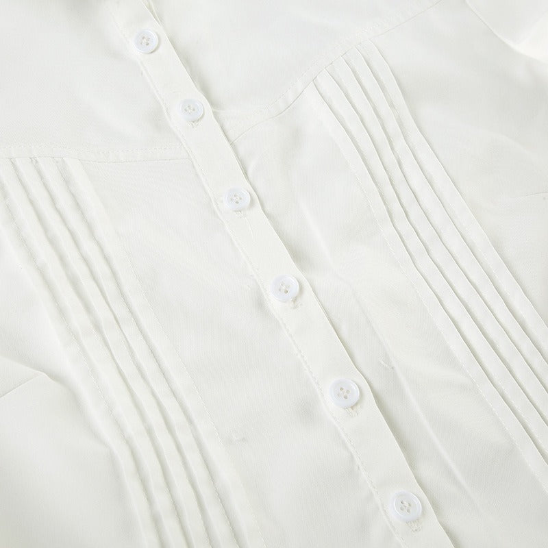 An extreme closeup of the textured pintuck pleats on the white formal blouse.