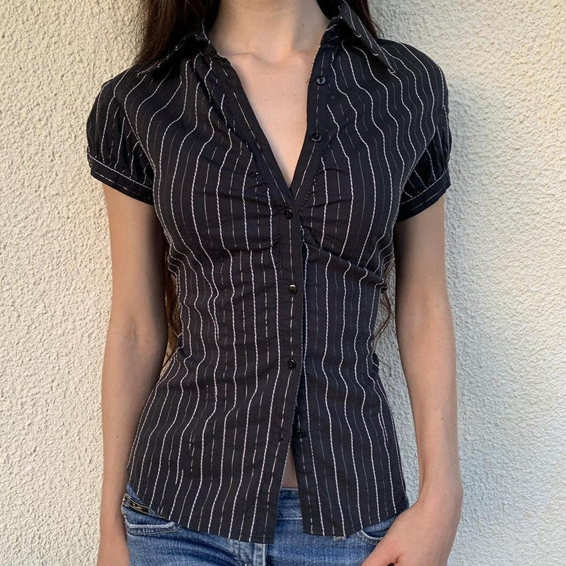 A woman modeling the pinstripe blouse styled as a casual shirt with jeans and an open collar.
