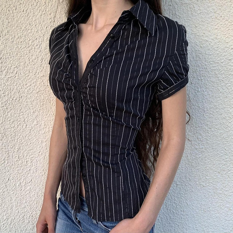 Side view of the fitted pinstripe blouse on a model, highlighting its body-contouring shape.