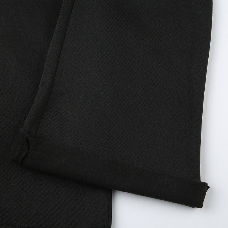 The wide leg opening and hem of the black flare sweatpants.
