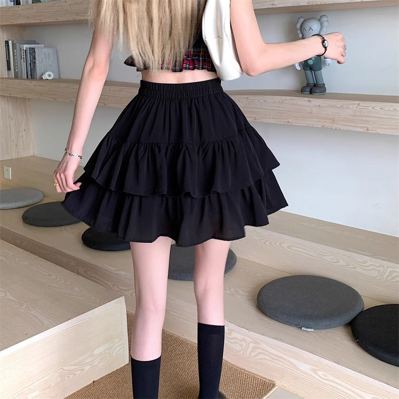A model from behind showing the movement and A-line silhouette of the black tiered ruffle skirt mini.